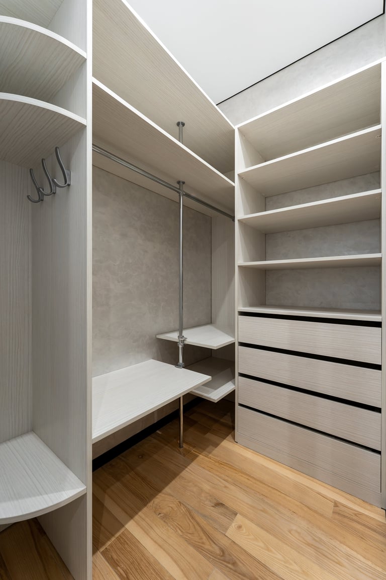 Modern walk in closet interior with wooden shelves drawers and clothing storage system